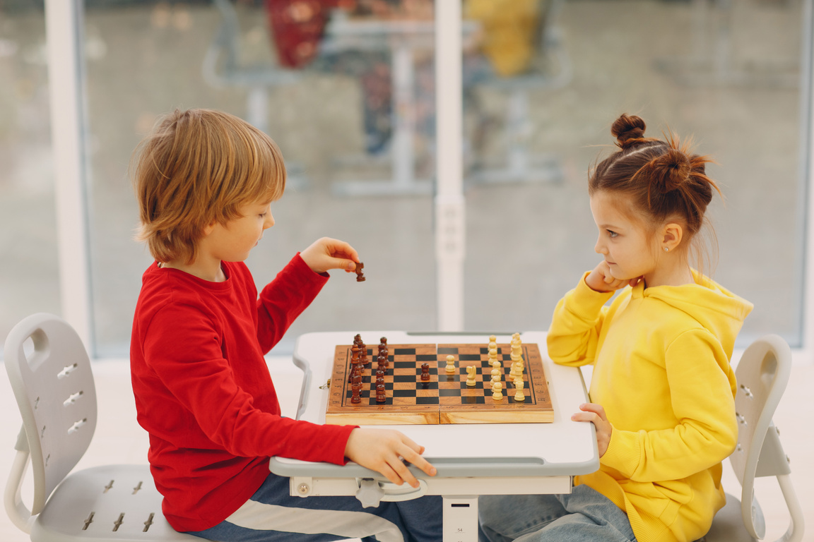 Little Kids Playing Chess at Kindergarten or Elementary School. Children's Chess Play.