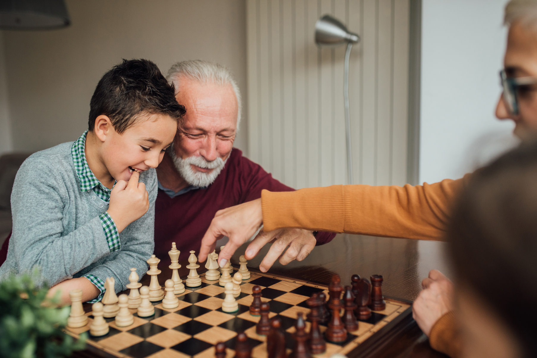 Grandparents playing chess with grandchild